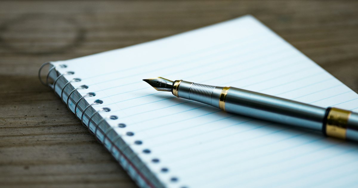 Caneta-tinteiro sobre caderno aberto