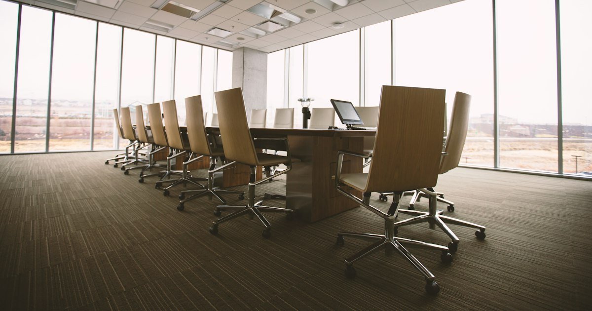 Sala de reuniões com mesa oval de madeira