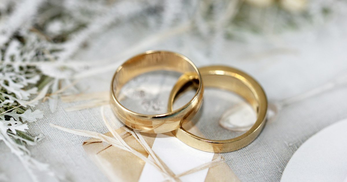 Aliança de casamento dourada sobre tecido branco